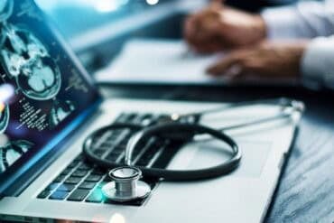 Doctor with laptop showing patient records data breach