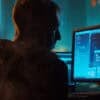 Hacker working on computer showing cyber attack on French supermarkets