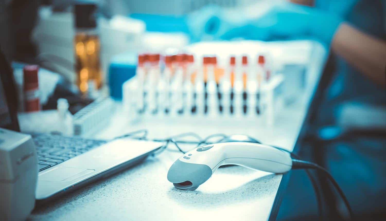 Bar codes scanner and blood sample tubes showing data breach at diagnostics lab