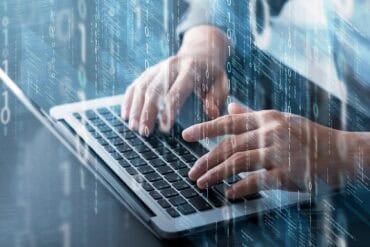 Developer on laptop showing AI coding tool exposes API keys
