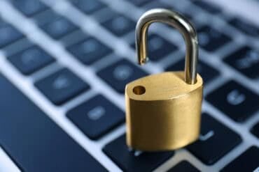 Metal padlock on laptop keyboard showing security flaw